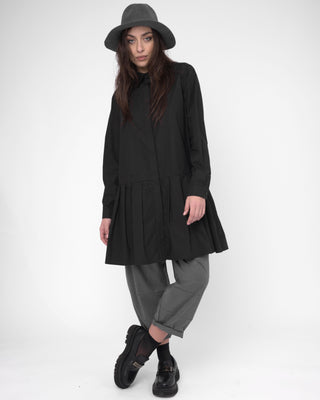 Person wearing a black coat, gray hat, and gray pants on a white background