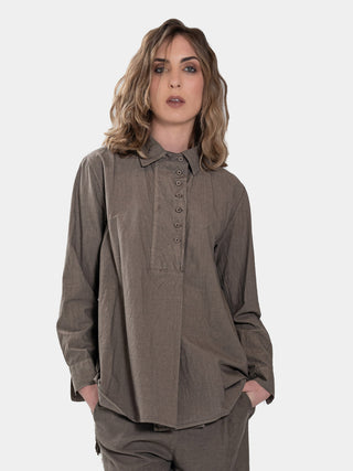 a model in a brown colored outfit standing against a white background
