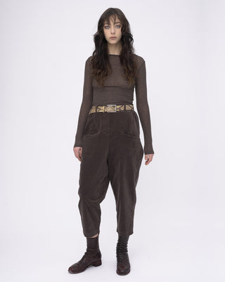Woman wearing a brown outfit with a belt on a white background