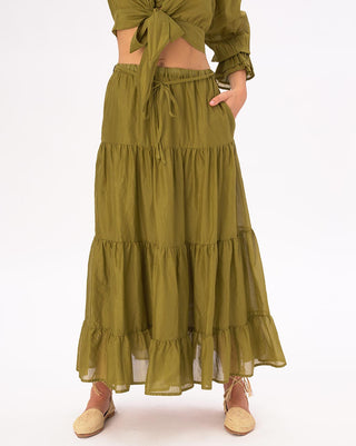 a woman standing wearing a green circle skirt against a white background