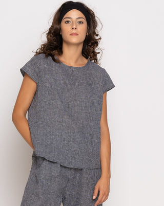 Woman wearing a gray checkered outfit against a white background