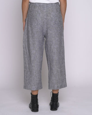 Person wearing gray checkered pants on a white background