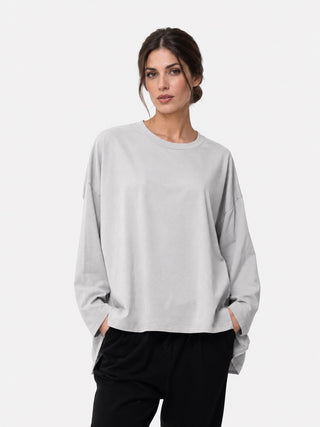 a model standing against a white background wearing a grey and black outfit