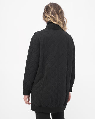 Person wearing a black quilted jacket on a white background