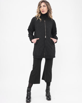 Woman wearing a black coat, pants, and boots on a white background