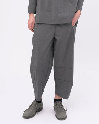 Person wearing a gray outfit with wide-leg pants on a white background