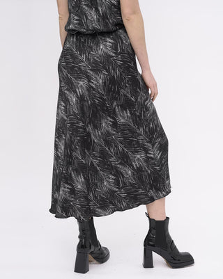 Person wearing a black and white patterned dress on a white background