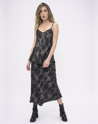 Woman wearing a black patterned dress on a white background