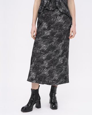 Person wearing a black and white patterned dress with black boots on a white background