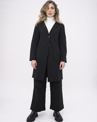 a model dressed in all black standing against a white background
