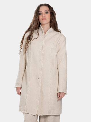 A female model wearing a long beige jacket with raw edge finish, standing against a white background.