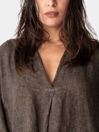 close up of a models chest to show the v-neckline of a brown dress