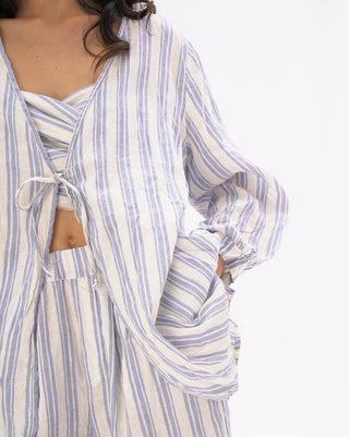 close up of a model wearing a light blue and white striped outfit against a white background