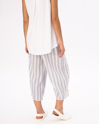 A model wearing striped elastic waist crinkled culottes with a white top and white shoes.