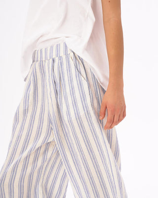A close up of a model wearing striped elastic waist crinkled culottes with a white top against a white background