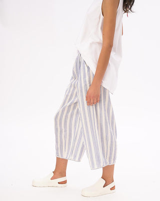 A model wearing striped elastic waist crinkled culottes with a white top and white shoes.