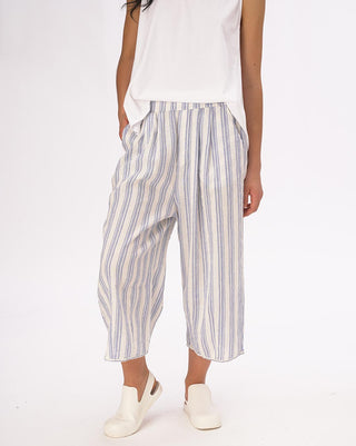 A model wearing striped elastic waist crinkled culottes with a white top and white shoes.