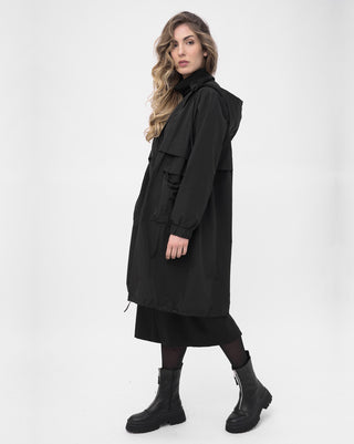 Woman wearing a black coat and boots on a white background