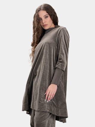 Woman wearing a brown poncho over a black top on a white background