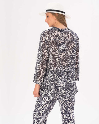 Person wearing a black and white patterned outfit with a hat on a white background