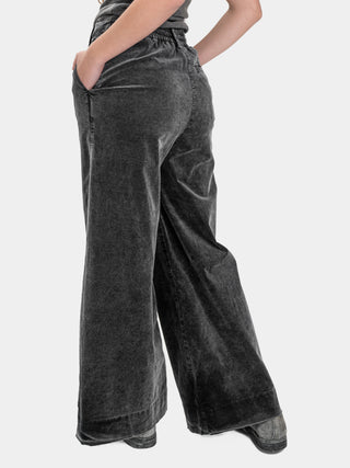 Person wearing dark gray wide-leg pants on a white background