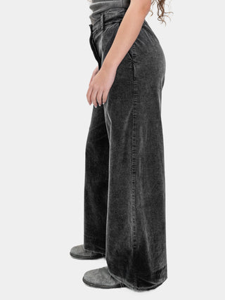 Person wearing black wide-leg jeans on a white background