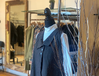 Mannequin wearing a striped outfit with a blurred clothing store background