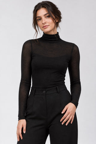 a brunette model on a light grey background wearing an all black outfit by baci fashion