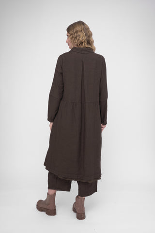 Person wearing a long brown coat on a white background