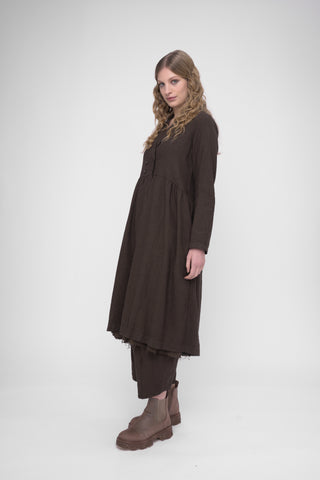 Woman wearing a brown dress and boots on a white background