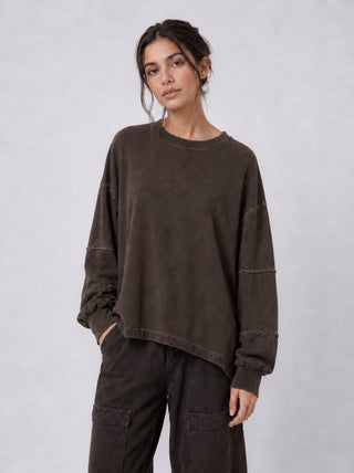 a model wearing a brown outfit by baci fashion against a light grey background