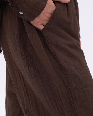 Brown pants with a close-up of the fabric texture on a white background