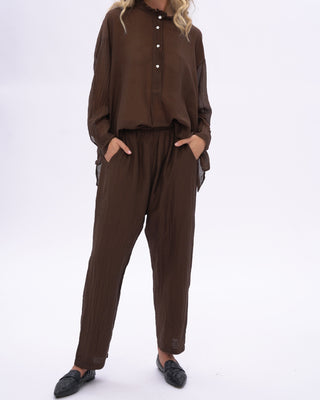 Person wearing a brown outfit on a white background