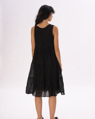 Black sleeveless dress worn by a model on a white background