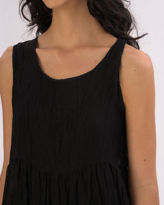 Black sleeveless dress worn by a person on a white background