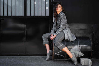 Woman sitting on a chair against a dark background wearing Baci Fashion