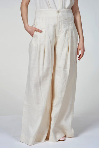 Person wearing white wide-leg pants on a plain background