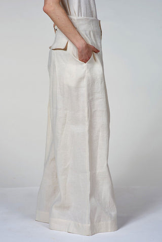 Person wearing white linen pants on a plain background