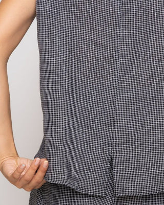 Close-up of a person wearing a black and white checkered outfit with a plain background