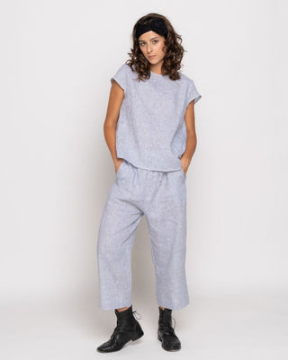 Woman wearing a gray outfit with wide-leg pants on a white background