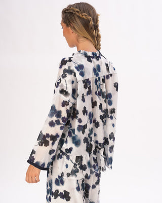 the back view of a model wearing a floral outfit against a white background