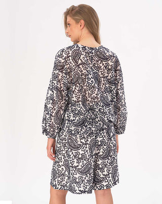 Woman wearing a black and white patterned dress on a white background