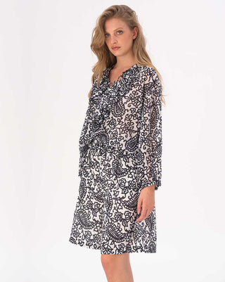 Woman wearing a black and white patterned dress on a white background
