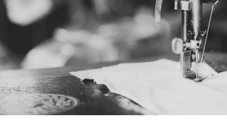 Close-up of a sewing machine needle on fabric with a blurred background