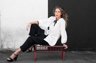 Woman sitting on a red bench against a black and white wall