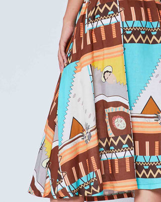 A close up of a maxi skirt featuring a geometric Aztec pattern in multicolor against a light grey background