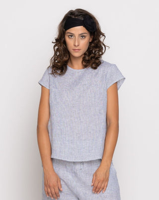 a model wearing a light blue colored outfit against a white background
