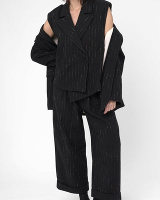 a woman wearing a striped black outfit against a white background.